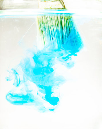 Blue Watercolor drops into the water on a white background.の写真素材