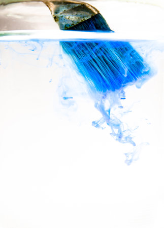 Blue Watercolor drops into the water on a white background.の写真素材
