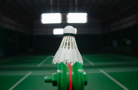 The shuttlecock is floating in a green badminton court net. background shot in low lightの写真素材