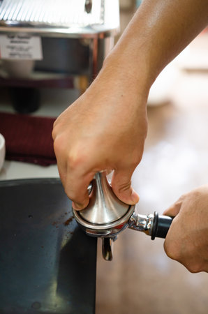An espresso shot is made by a barista to make a hot latte.の写真素材