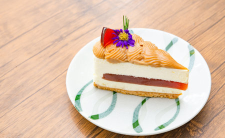 A close-up of  served Cheesecake decorated with flowers on a ceramic plate with a latte on a rustic...