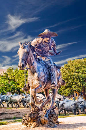Statue of a cowboy on horseback in the center of the city.の写真素材