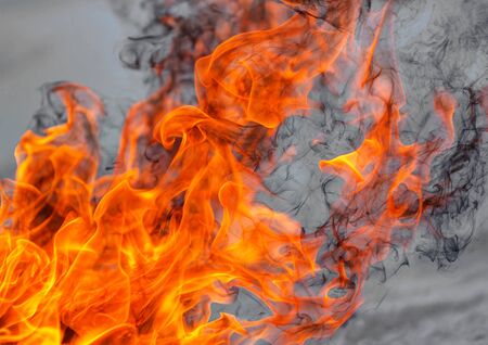 The flames of the fire in the day time