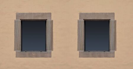 Two open windows on the background of painted wall.