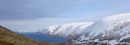 Lake in the background of the hills in the snow.