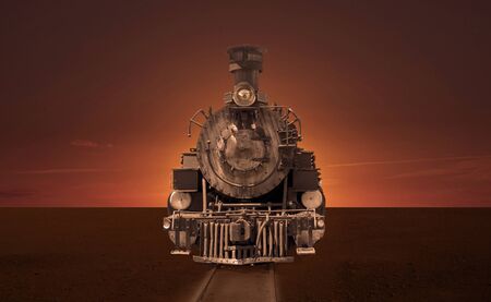 Old steam locomotive in the steppe at sunset