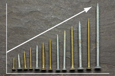 positive graph using various sized screws as bar charts on slate background
