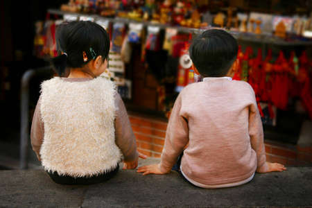 Boy and girl sitting next to each otherの写真素材