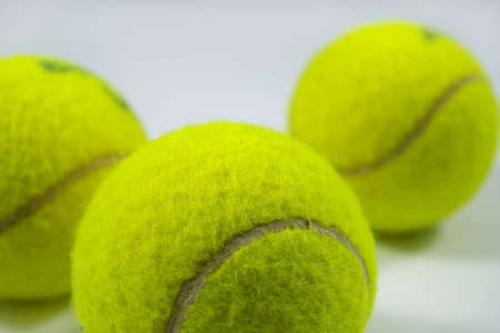 tennis balls on gray with shadowsの写真素材
