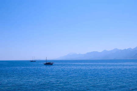 sea landscape with silhouette of mountains and two shipsの写真素材