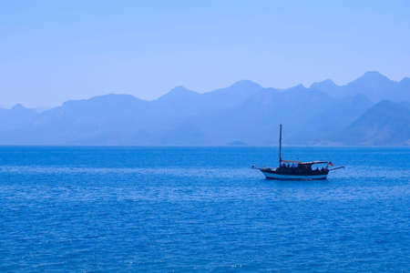 sea landscape with ship and silhouette of mountainsの写真素材