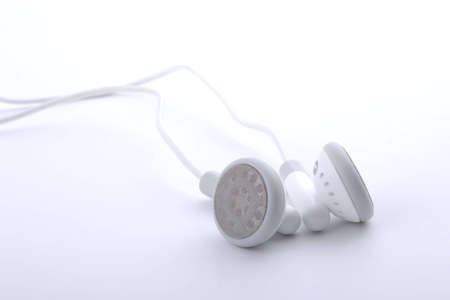 small portable white headphones on grey backgroundの写真素材