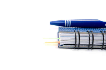 blue notebook and blue pen isolated on white backgroundの写真素材