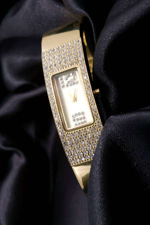 woman golden watch with crystals on back backgroundの写真素材