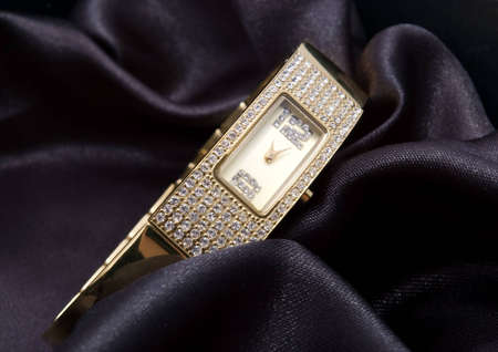 golden woman watch with crystals on black backgroundの写真素材