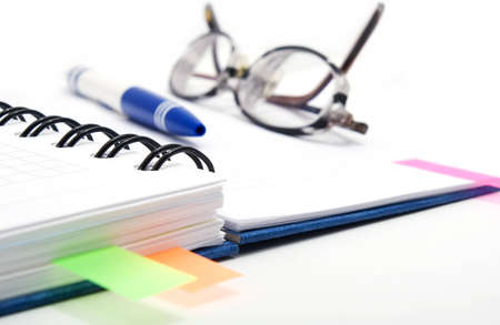 open notebook with color bookmarks, pen and glassesの写真素材