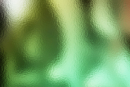 abstract background with green and black spots on the surface of glassの写真素材