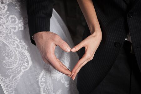 Heart from hands against wedding dressesの写真素材
