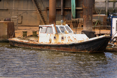 small rusty old ship lying in the Lauwersoog harbor next to the dockの写真素材