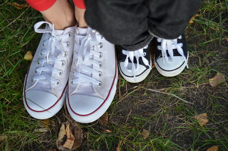 Mom and son legs on the grass in the sneakersの写真素材