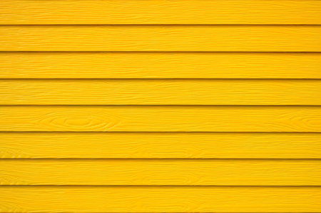 Wall panel paint yellow color synthetic wooden plank texture surface background.Outdoor panel engineered wood nature pattern or abstract backdrop vintage lines,summer design and decoration.Soft image.の写真素材