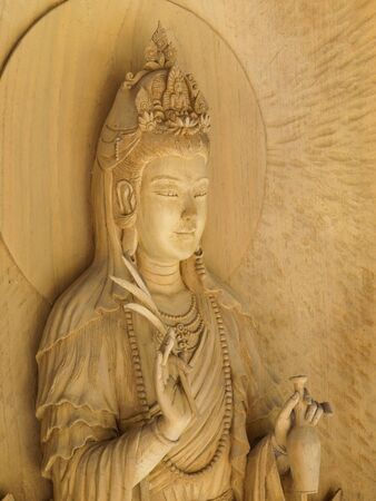 Kuan Yin image of buddha , Wood carving in a thai temple.の写真素材
