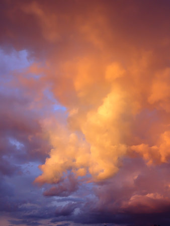 Dramatic storm clouds in the sky. Hot turbulent orange sunset.