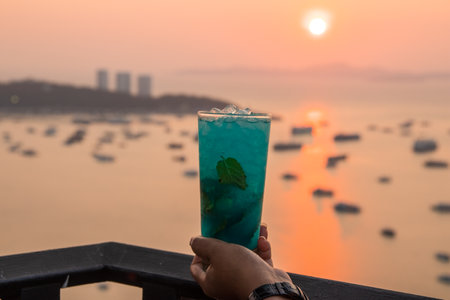 One Blue Mojito Cocktail drink with sunset on the beach at Pattaya, Thailandの写真素材