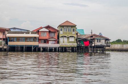 Colorful wooden houses on stilts over the Chao Phraya River in Bangkok, Thailandの写真素材
