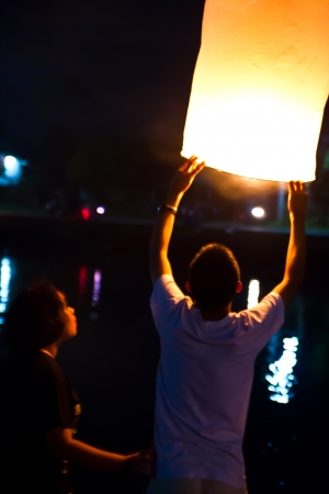 CHONBURI, THAILAND - NOVEMBER 28: Two people holding a flying fire lantern to celebrate the Loy Krathong festival. November 28, 2012 in Hua Hin, Thailand.のeditorial素材