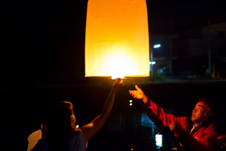 CHONBURI, THAILAND - NOVEMBER 28: Two people holding a flying fire lantern to celebrate the Loy Krathong festival. November 28, 2012 in Hua Hin, Thailand.のeditorial素材