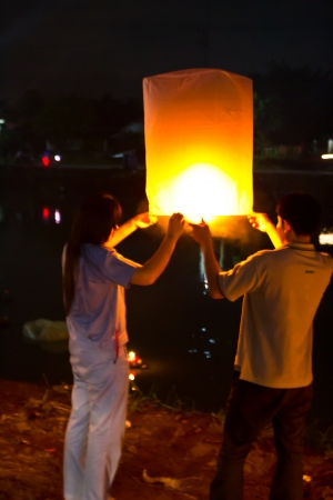 CHONBURI, THAILAND - NOVEMBER 28: Two people holding a flying fire lantern to celebrate the Loy Krathong festival. November 28, 2012 in Hua Hin, Thailand.のeditorial素材