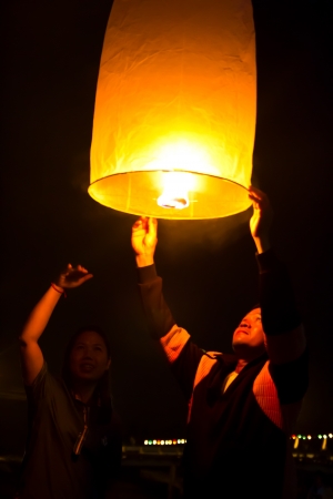 CHONBURI, THAILAND - NOVEMBER 28: Two people holding a flying fire lantern to celebrate the Loy Krathong festival. November 28, 2012 in Hua Hin, Thailand.のeditorial素材