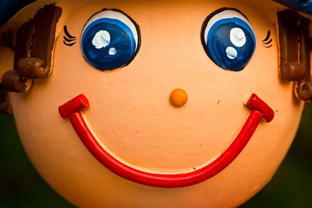 Face of smile baked clay doll, close upの写真素材
