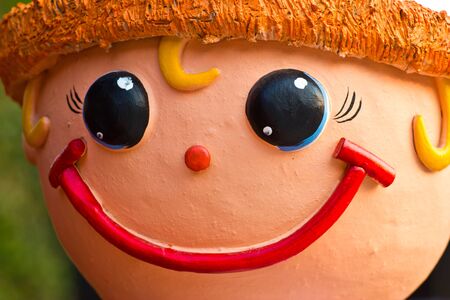 face of smile baked clay doll, close upの写真素材