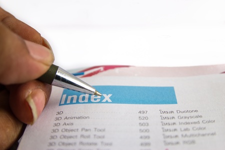 close up detail of an open book with a silver pen laying on it.の写真素材