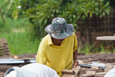 Man laborer lifts the wood of Production of bricks in thailandの写真素材