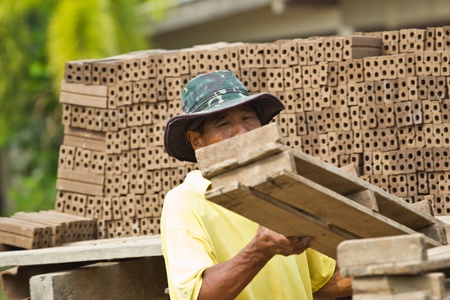 Man laborer lifts the wood of Production of bricks in thailandの写真素材