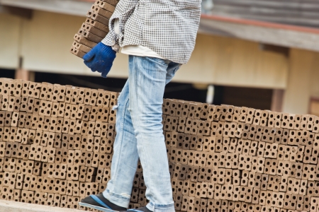 Woman laborer is dislocating a brick of Production of bricks in thailandの写真素材