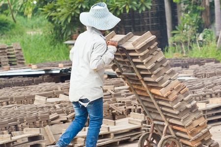 Woman laborer lifts the wood of Production of bricks in thailandの写真素材