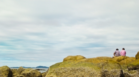 two older man sitting on the stone and looking at sky ,bangsean beach chonburi thailand の写真素材