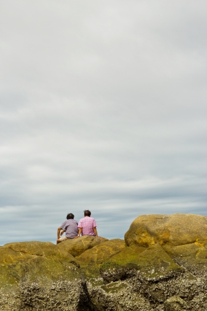 two older man sitting on the stone and looking at sky ,bangsean beach chonburi thailand の写真素材
