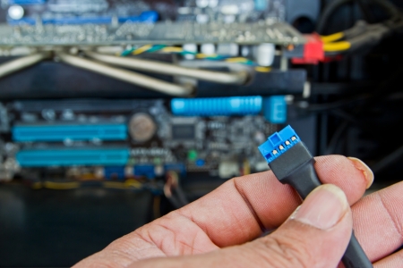 Close up of a technician's hands wiring computer parts