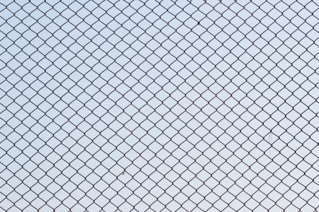 Metal mesh wire fence with blur sky backgroundの写真素材