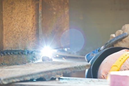 outdoor worker with protective mask welding metal and sparks