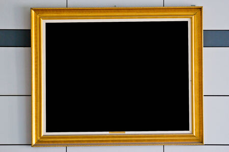 gold picture frame. Isolated over wall   の写真素材