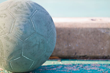 Old used football or soccer ball on cracked asphaltの写真素材