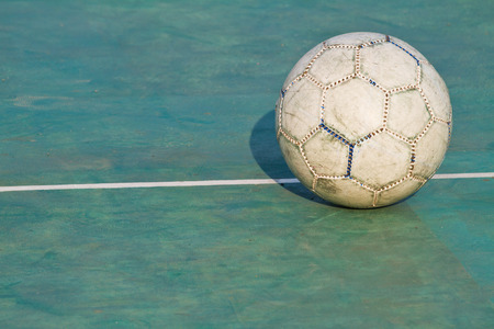 Old used football or soccer ball on cracked asphaltの写真素材