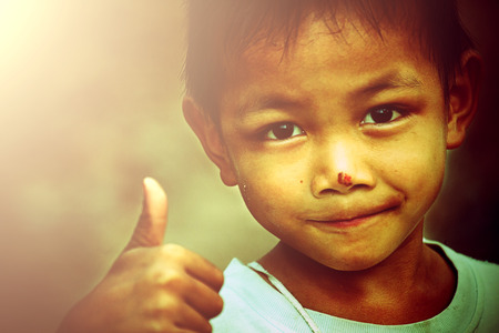 Portrait of beautiful little boy giving you thumbs up over white backgroundの写真素材