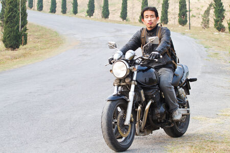 Low angle view of man riding bike against clear skyの写真素材